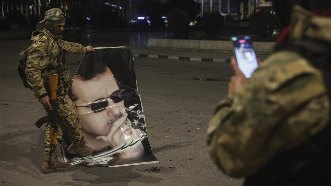 A fighter stepping on a portrait of Syrian President Bashar Assad