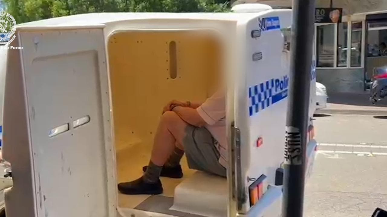 The priest in the back of a police wagon