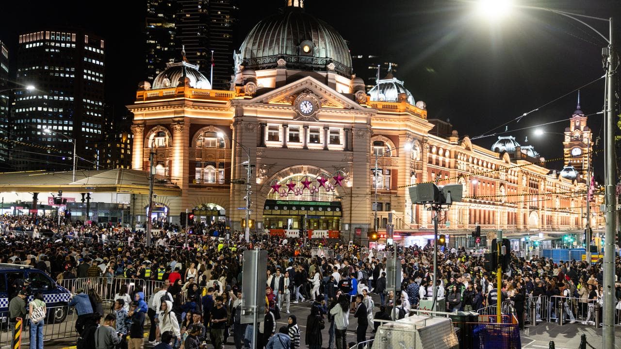 People walk along St Kilda Road on New Year’s Eve in Melbourne