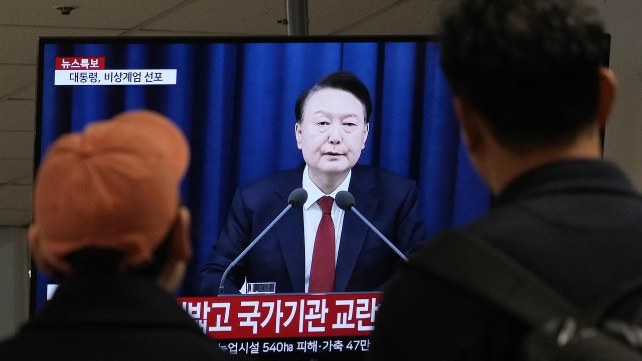 A TV screen showing South Korean President Yoon Suk-yeol