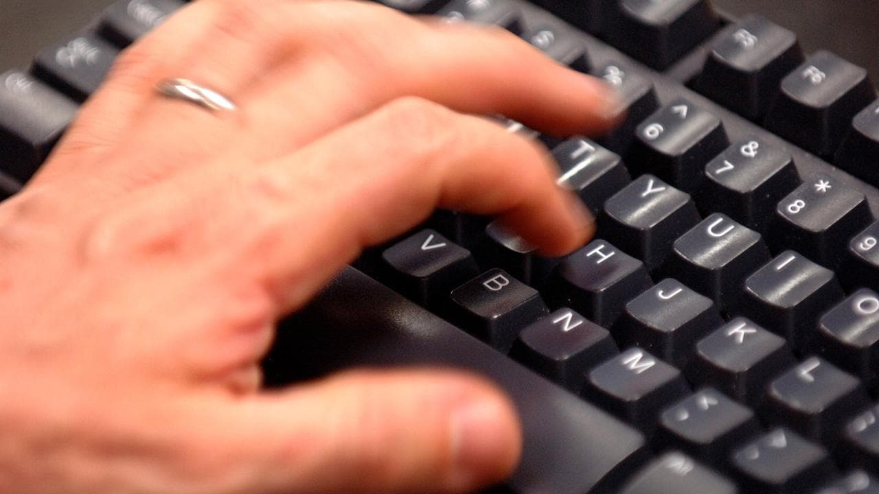 Office worker types on a computer keyboard