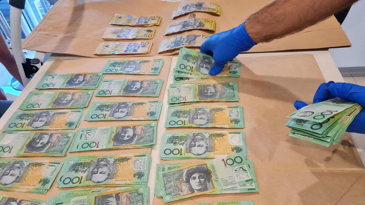 police counting cash seized from a drug bust