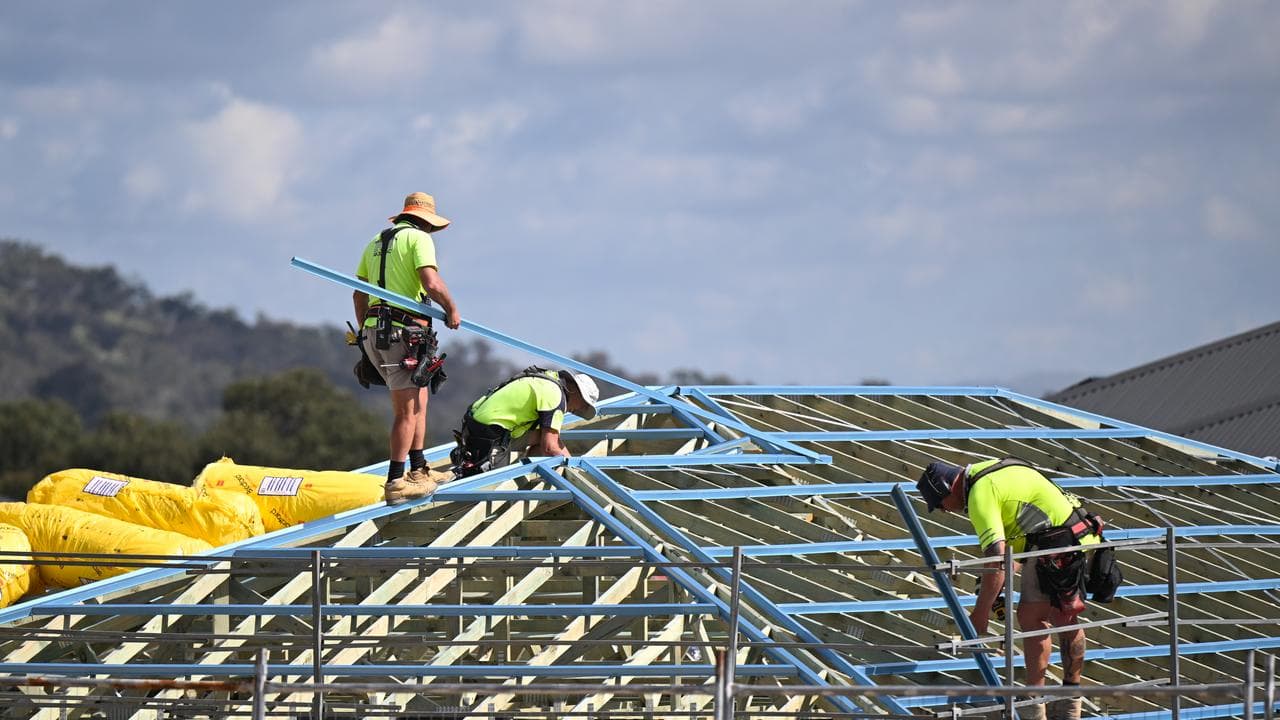 Roofers work on a house