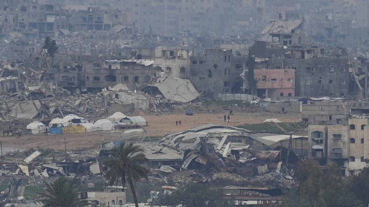 Palestinians are seen near destroyed buildings