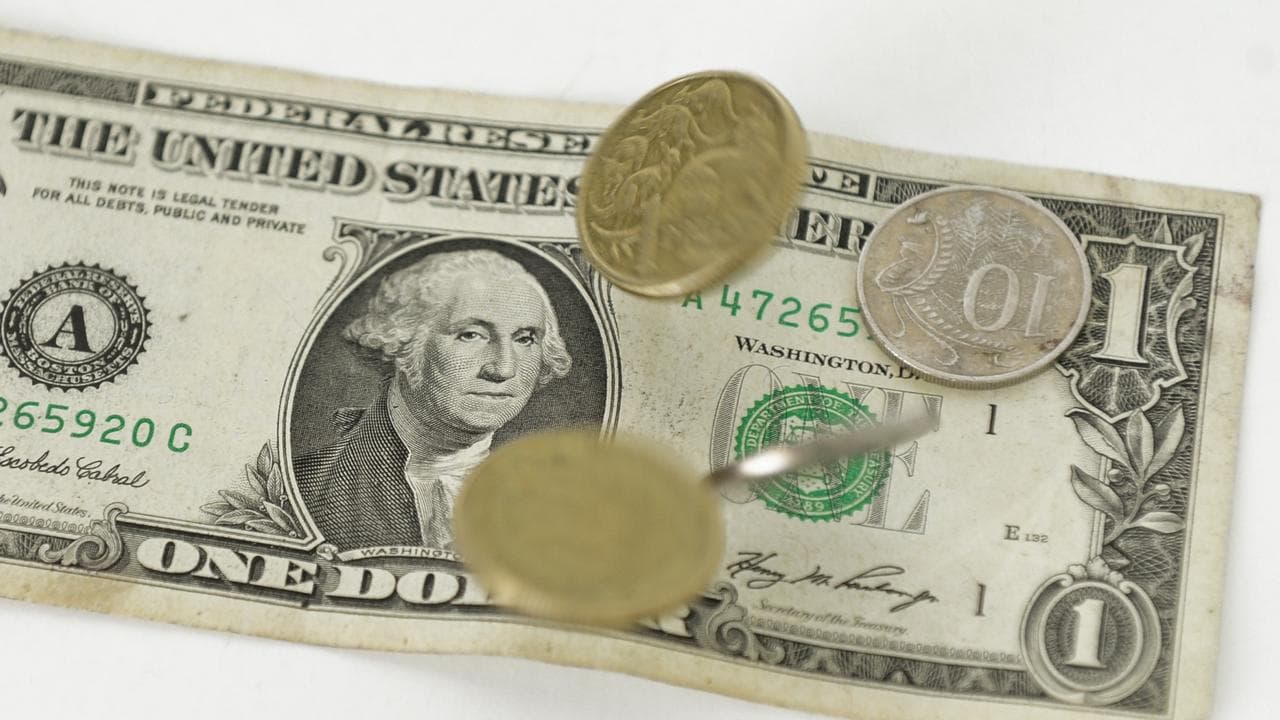 Australian dollar coins fall onto a US one dollar note (file image)