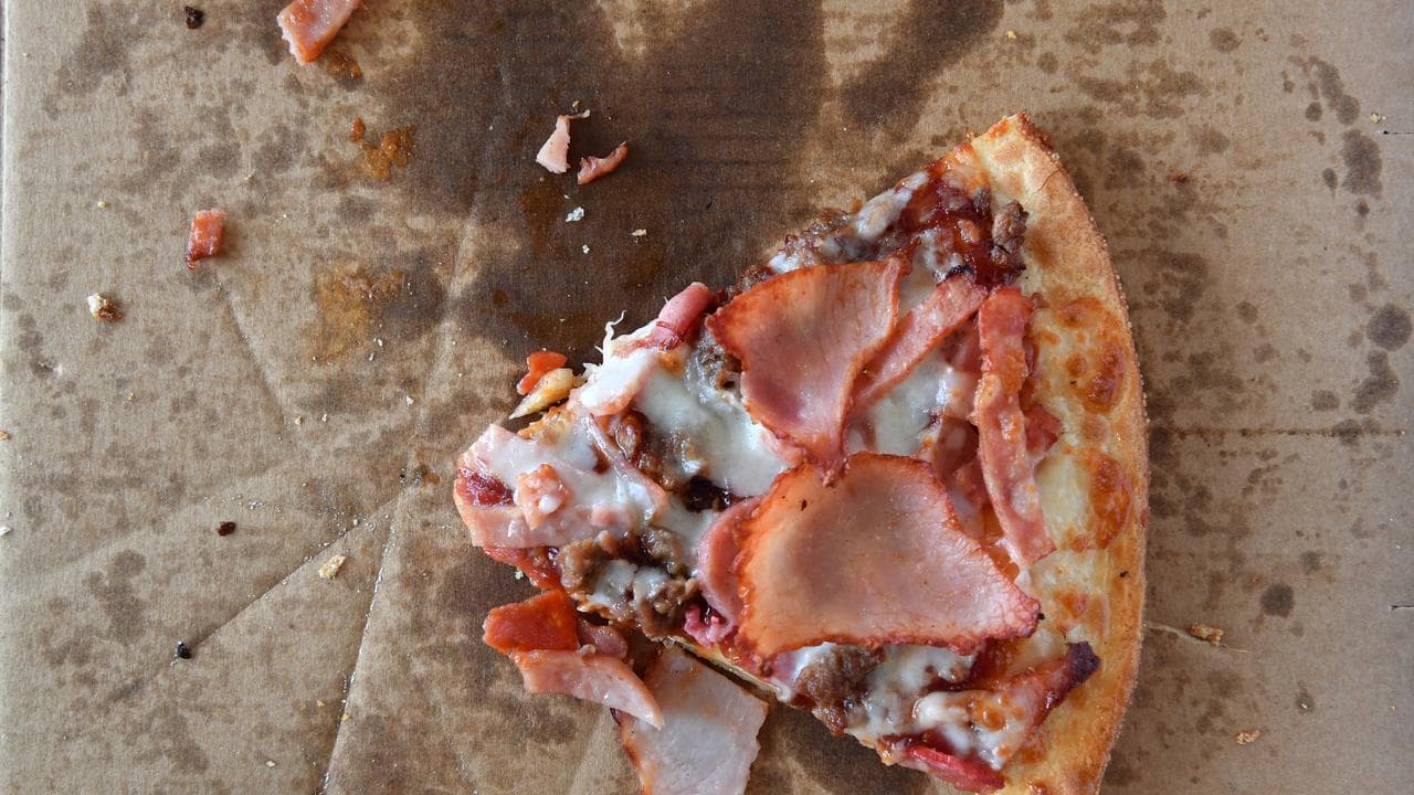 A silce of pizza in a cardboard box.