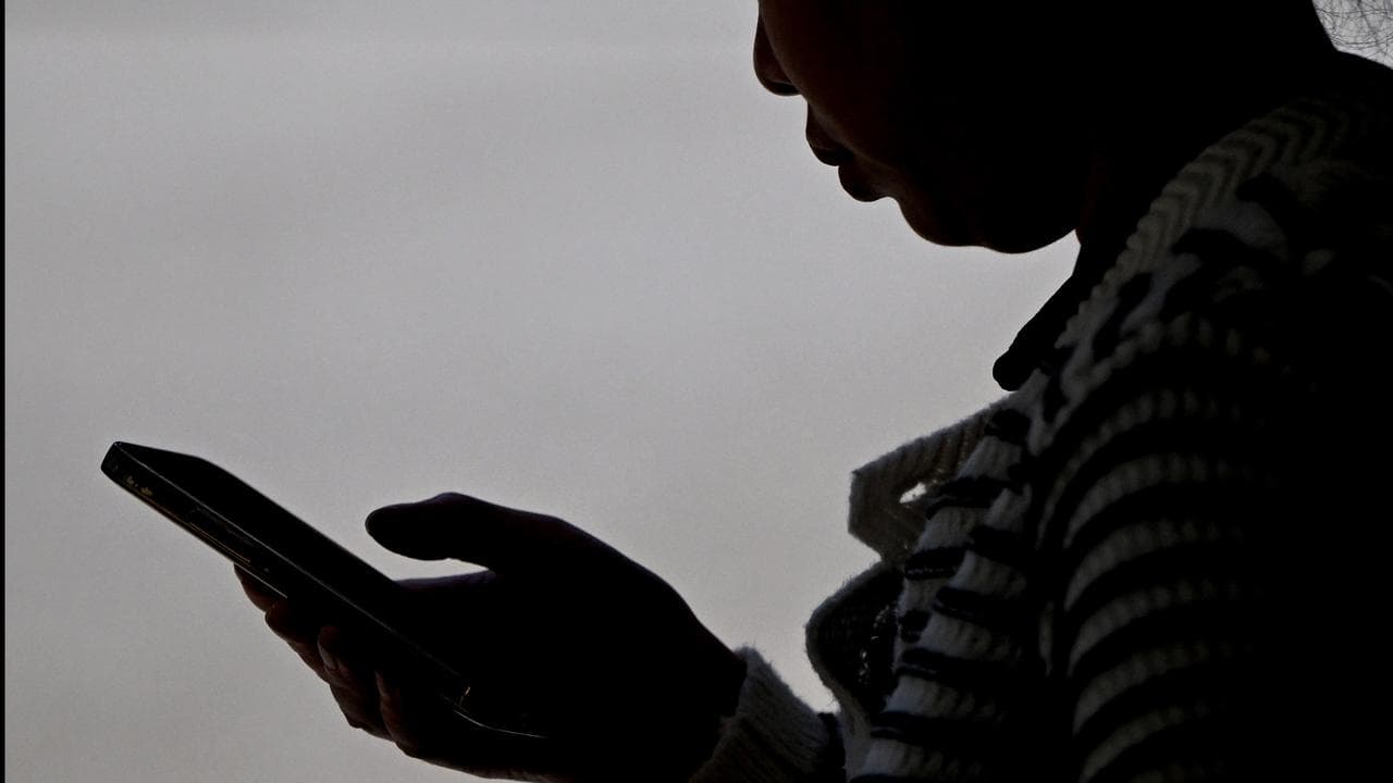 A woman in silhouette using a smartphone device