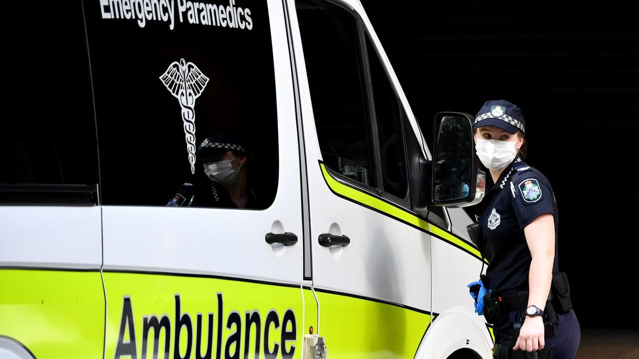 A police officer is seen directing an ambulance