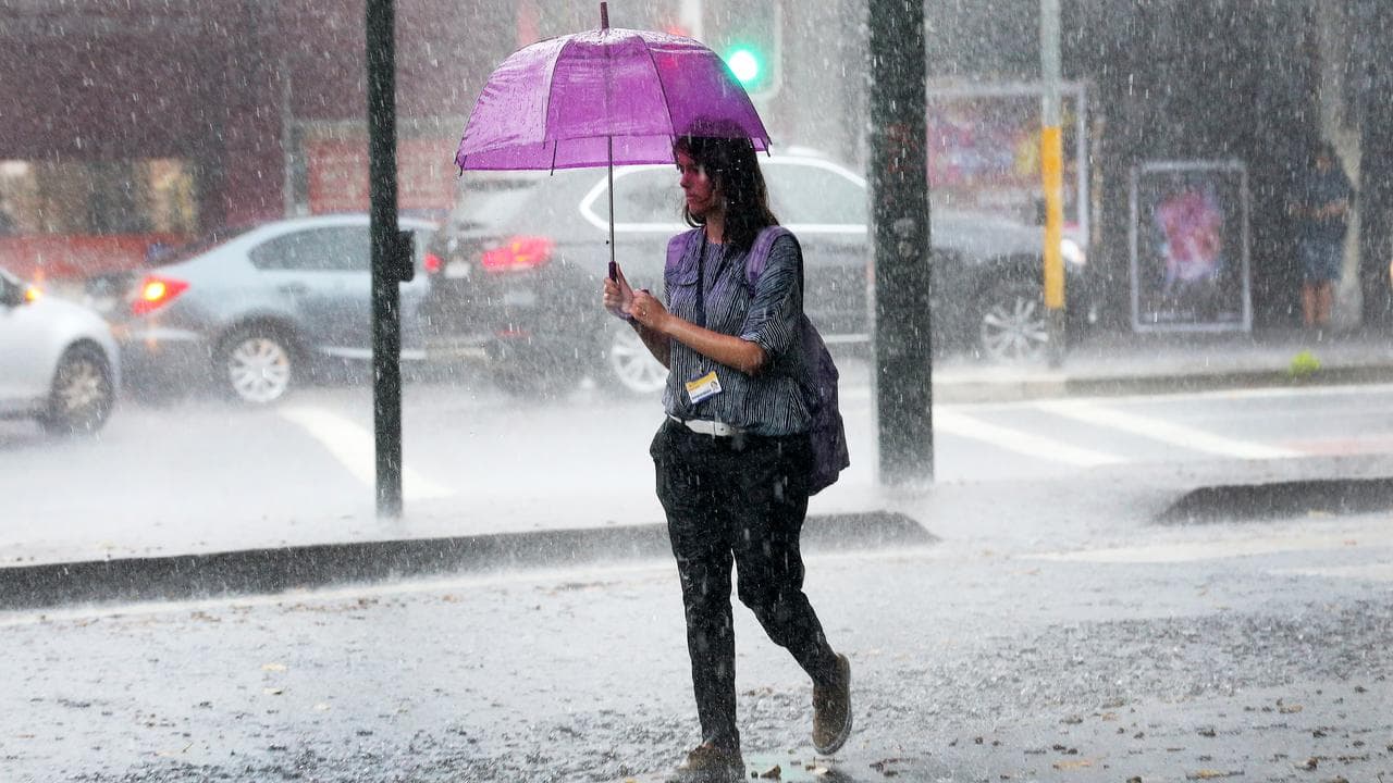 A woman walks during heavy rain