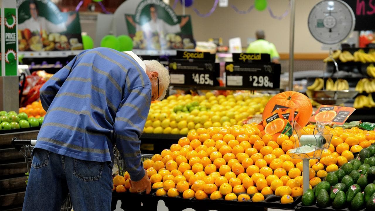 A shopper inspects fruit inside a Woolworths store in Brisbane, 2011