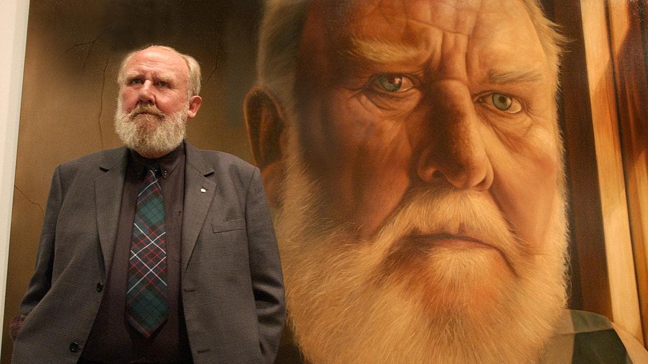 Bill Hunter stands in front of his portrait