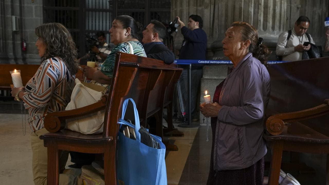 People pray for Pope Francis at the cathedral in Mexico City