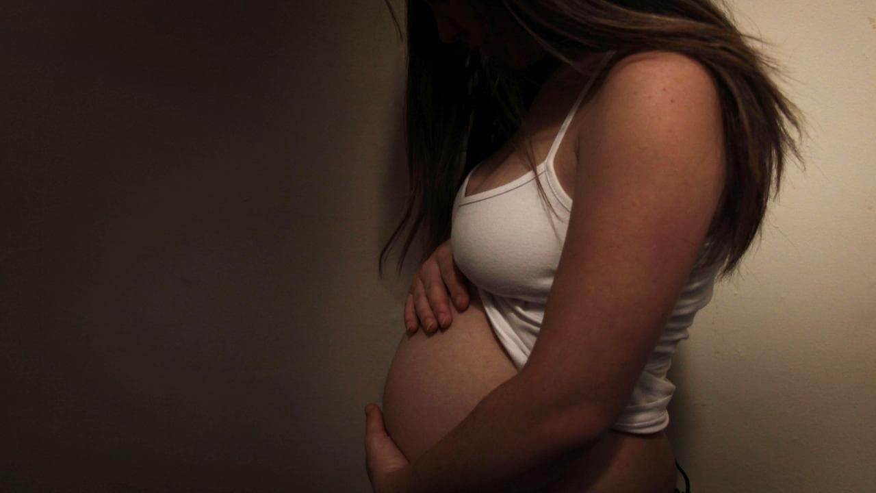 An unidentified pregnant woman poses for a photograph