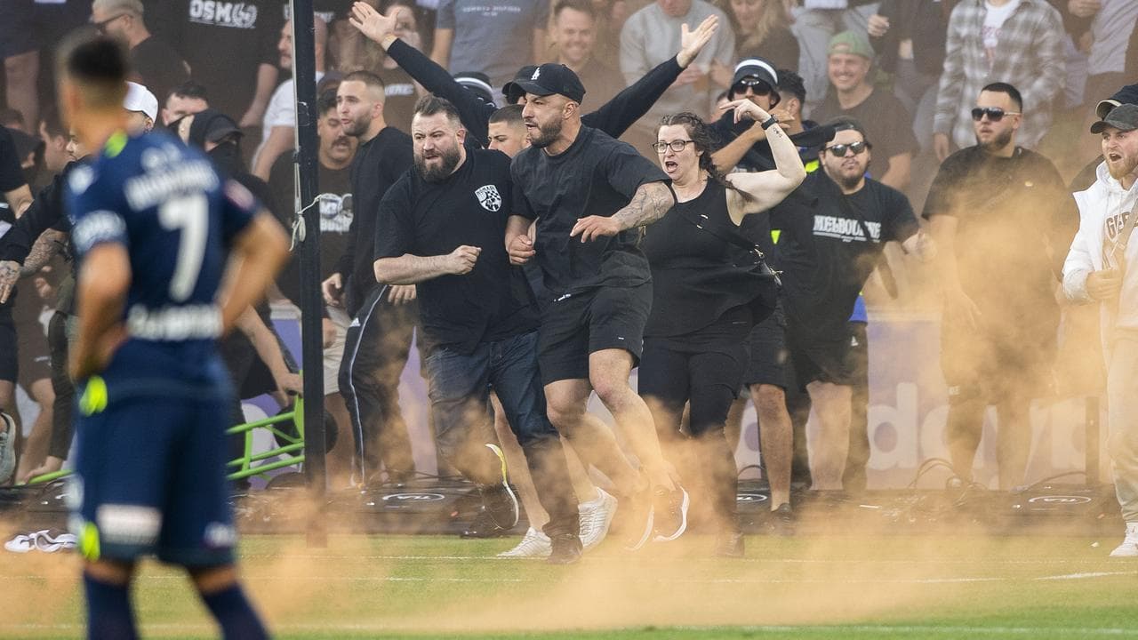 Melbourne Victory fans invade the pitch.