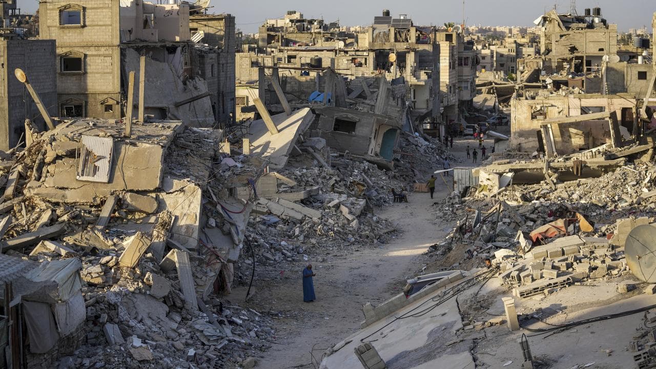 Palestinians walk through the destruction (file image)