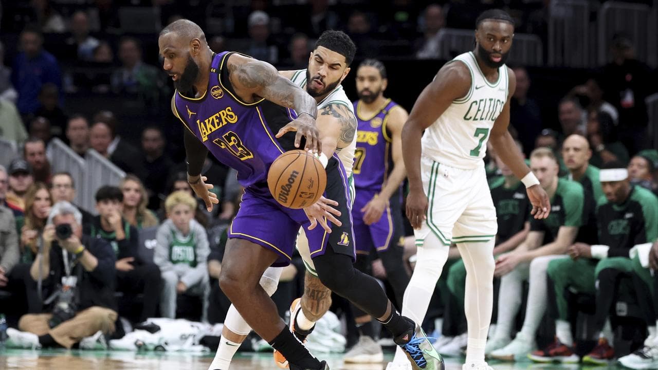 Jayson Tatum (centre) knocks the ball loose from  LeBron James.