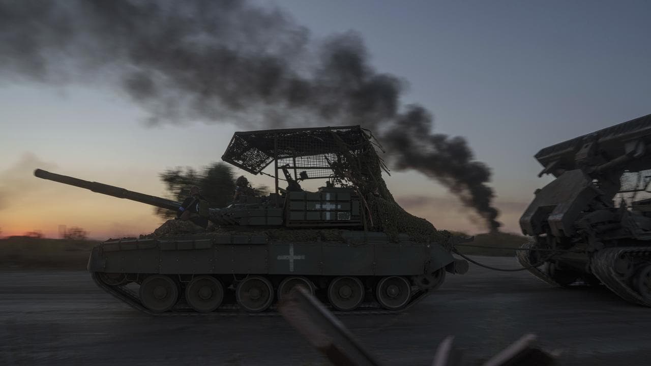 Ukrainian servicemen ride atop a tank