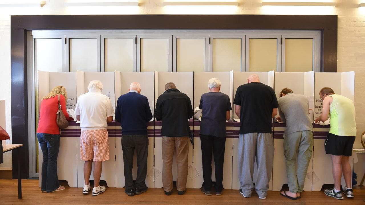 Voters are seen filing out ballot papers