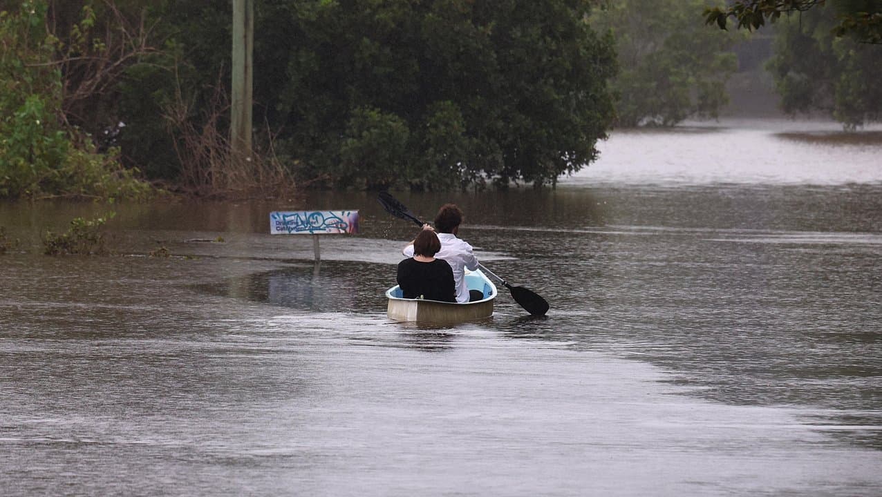 Couple canoe in flood waters