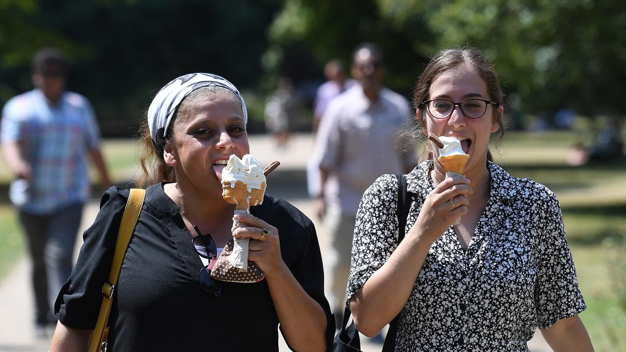 Two women eating ice cream cones.