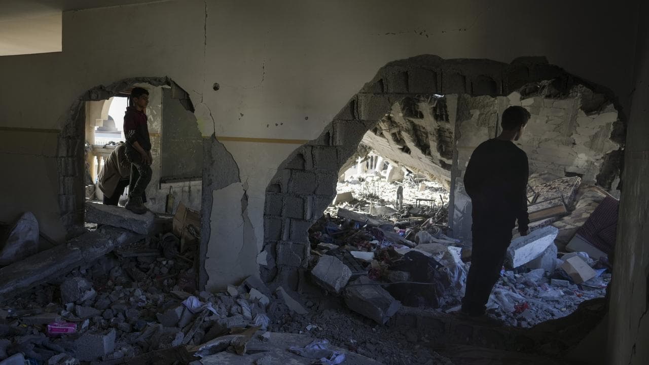 Palestinians inspect the damage following an Israeli air strike