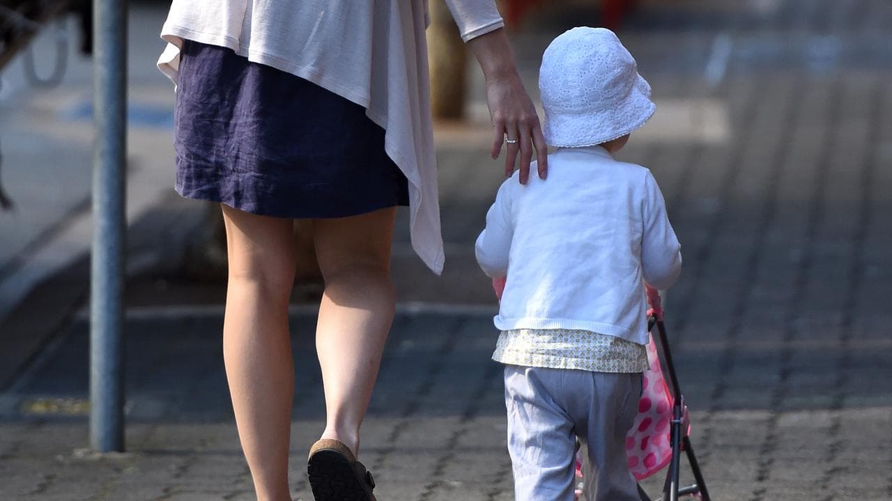 A woman and toddler pushing a toy stroller