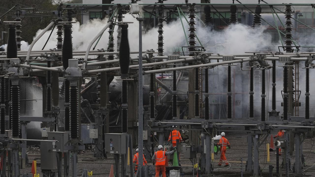 Workers as smoke rises from the North Hyde electrical substation