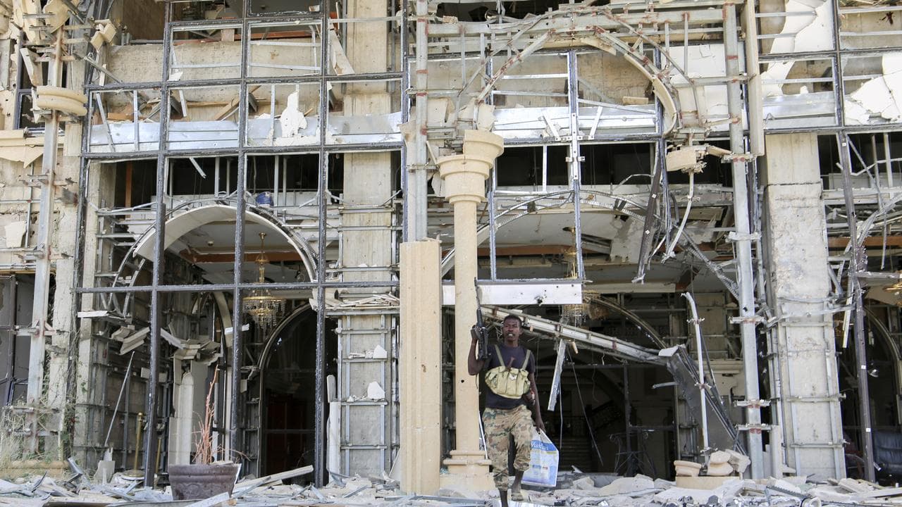 A soldier walking in front of damaged Republican Palace