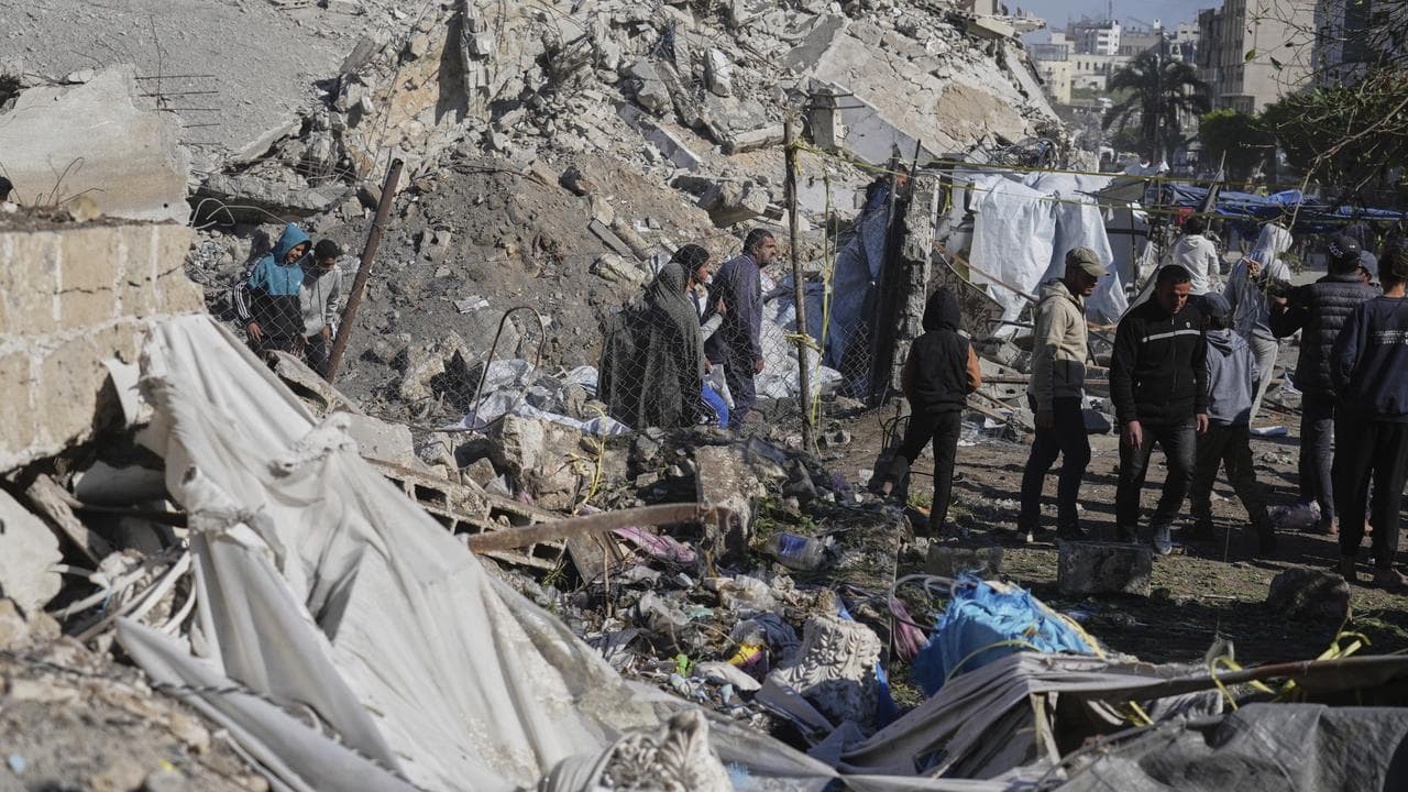 Palestinians inspect the site hit by an Israeli bombardment, in Gaza