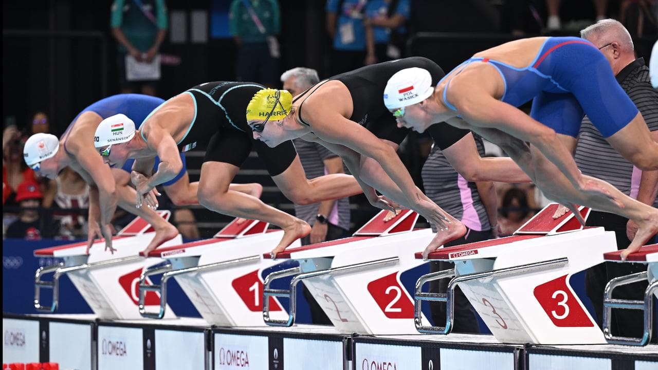 Swimmers dive off the blocks in an Olympics heat in Paris