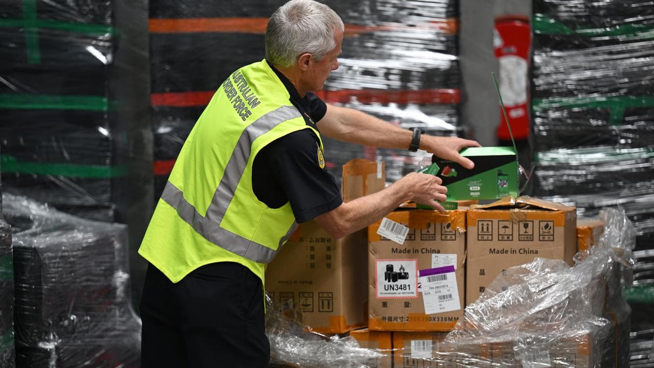 An Australian Border Force officers inspects cartons of seized vapes