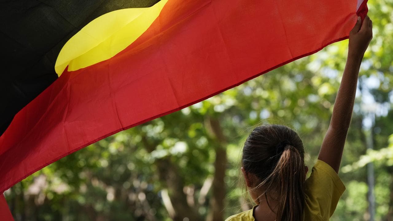 A young holds an Aboriginal flag