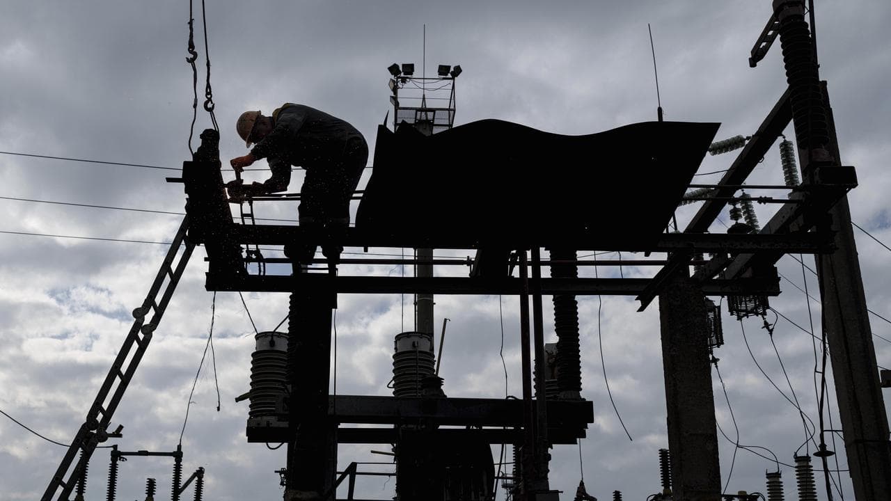 Man repairs a substation hit by Russian drones in Ukraine