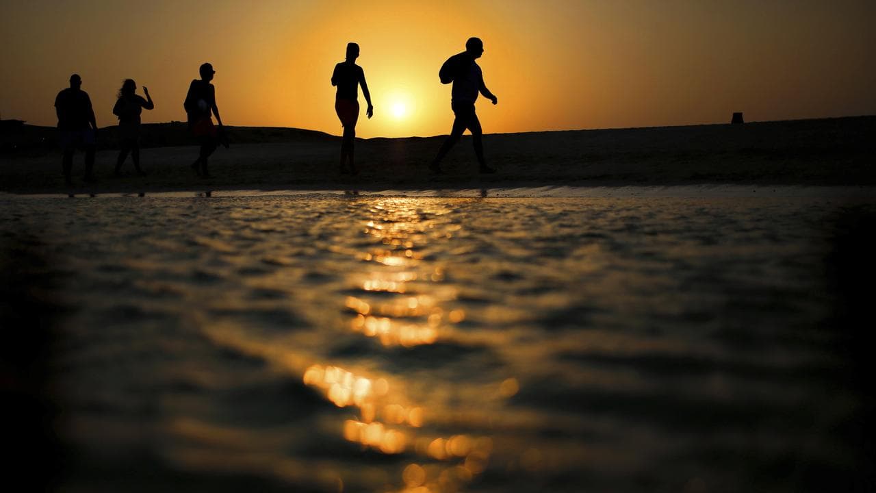 Tourists walk on the beach in Hurghada