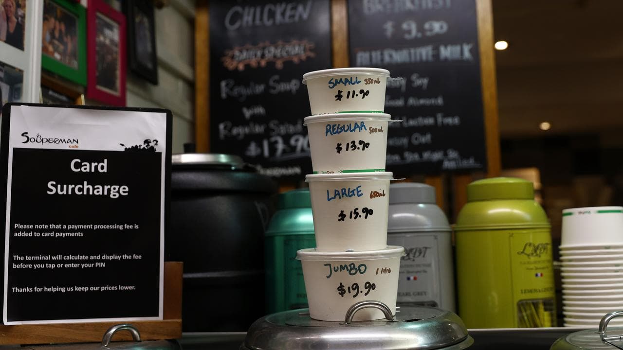 Stack of soup cups with prices written on them at Souperman Cafe