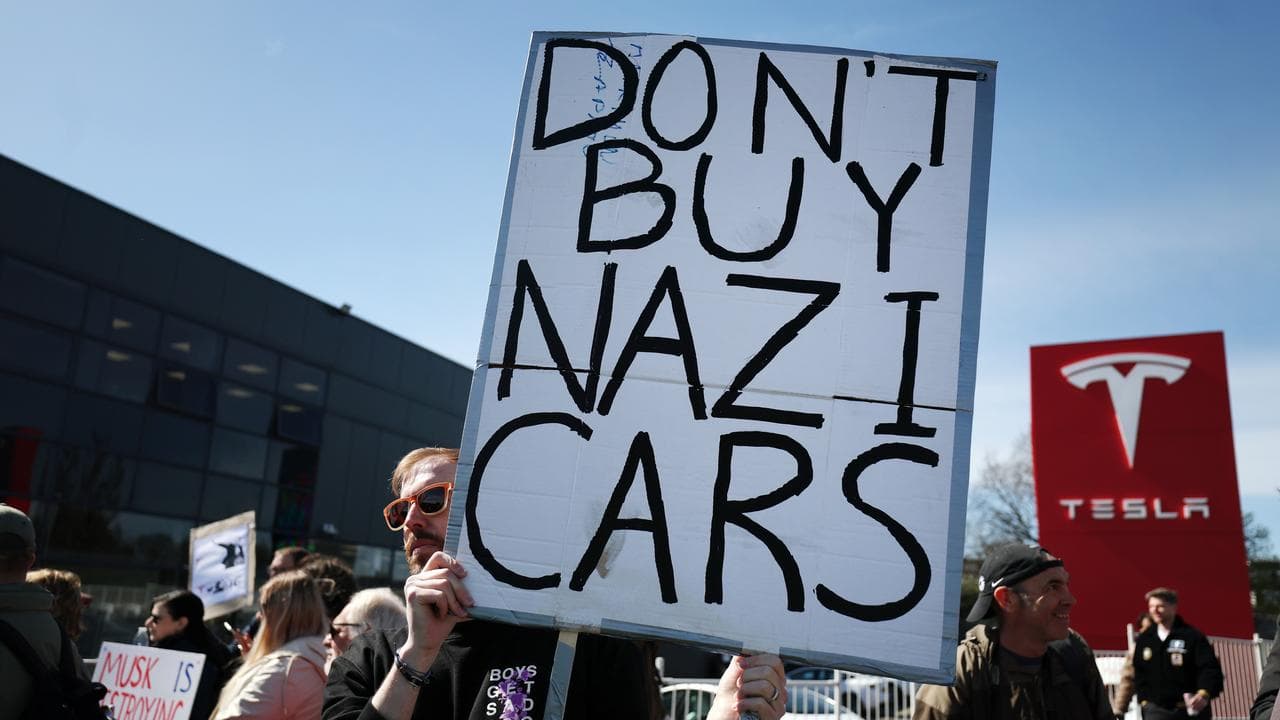 Protesters with a 'Don't Buy Nazi Cars' sign