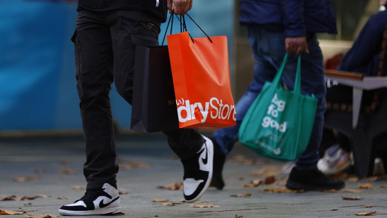 People walk in front of retail stores in Perth, June 21, 2022