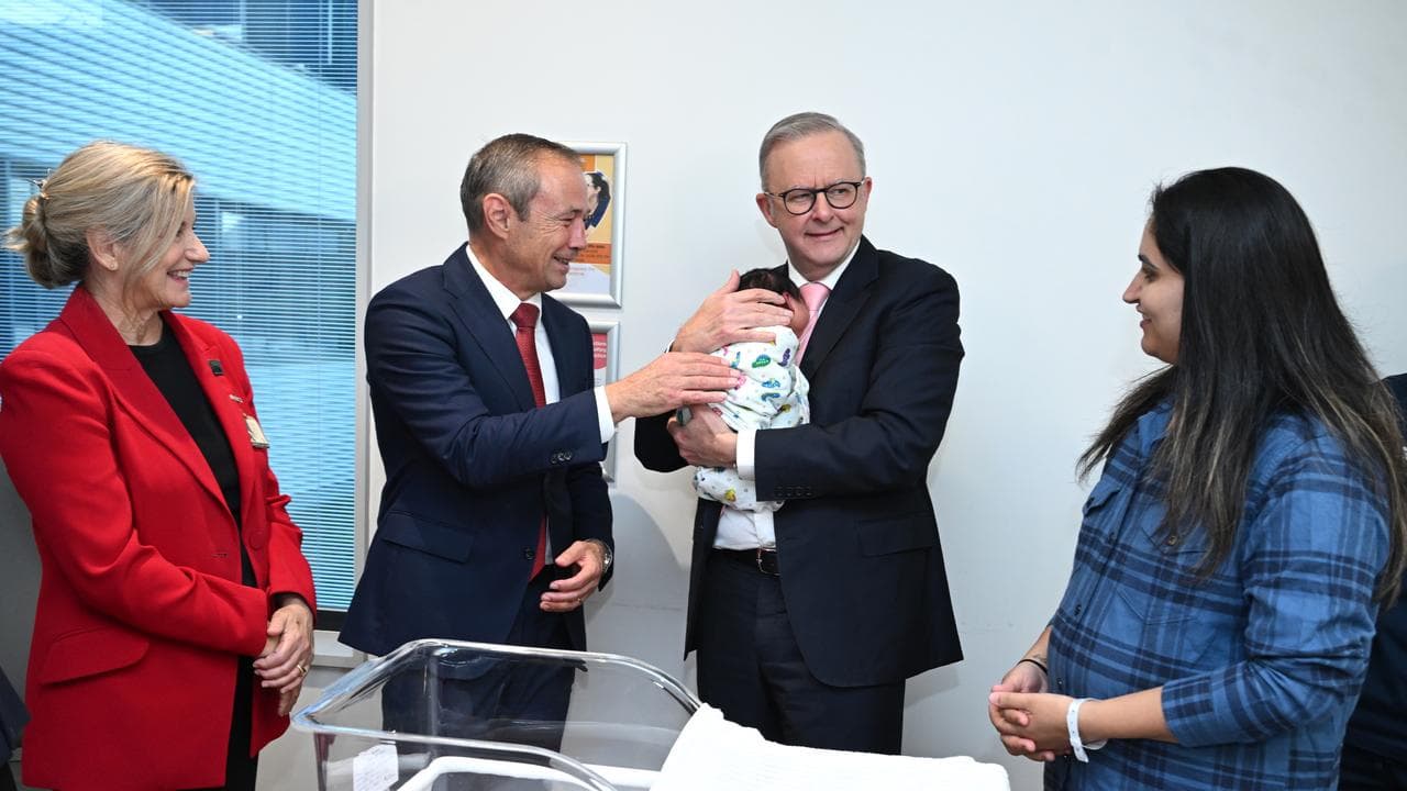 Prime Minister Anthony Albanese holds a baby in campaigning in Perth