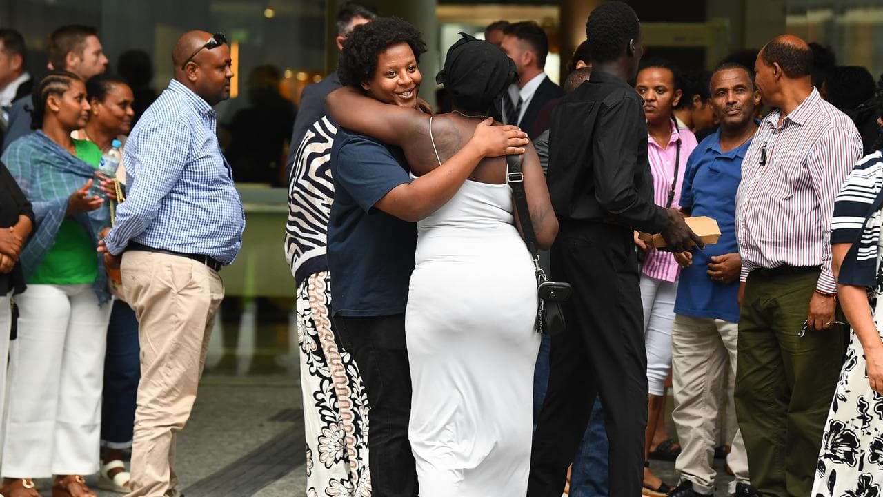 Victim family members embrace outside Brisbane Supreme Court