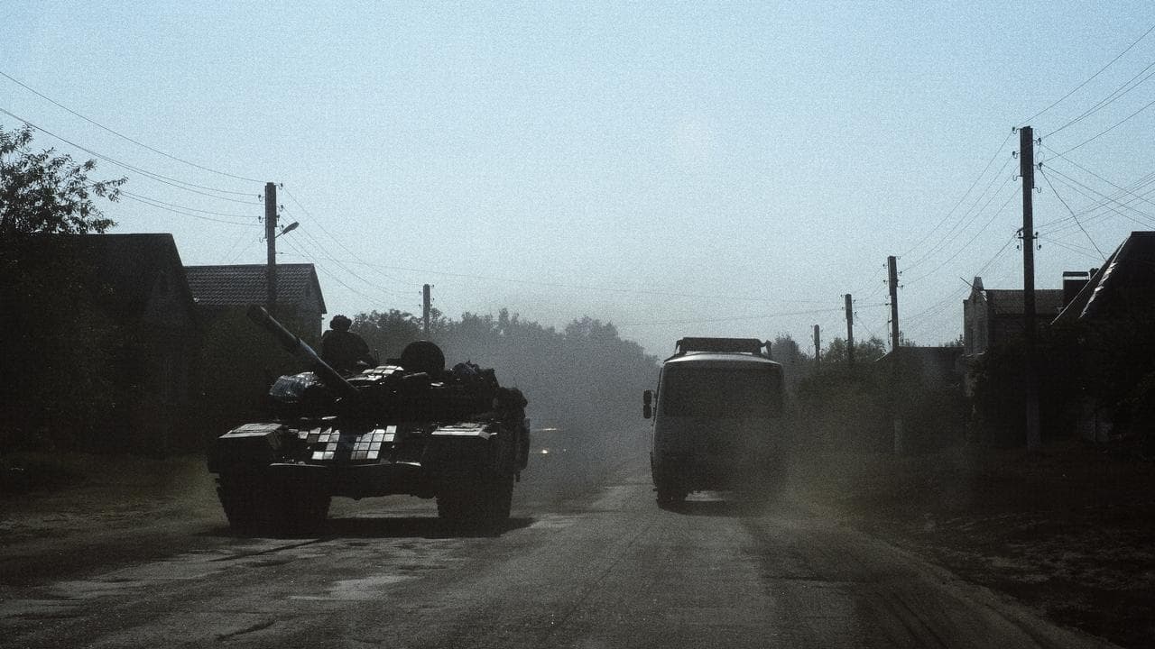 A bus drives past a Ukrainian tank in the Sumy region.