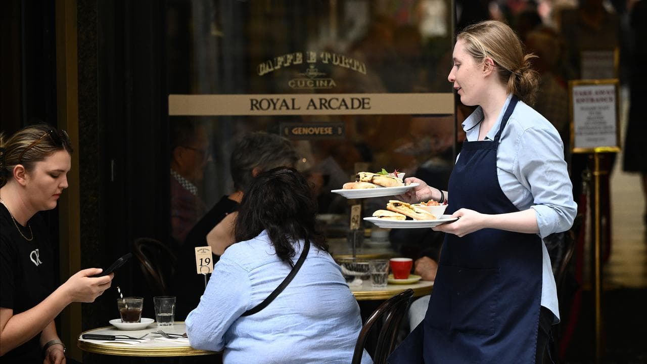 A cafe worker serves coffee in Melbourne