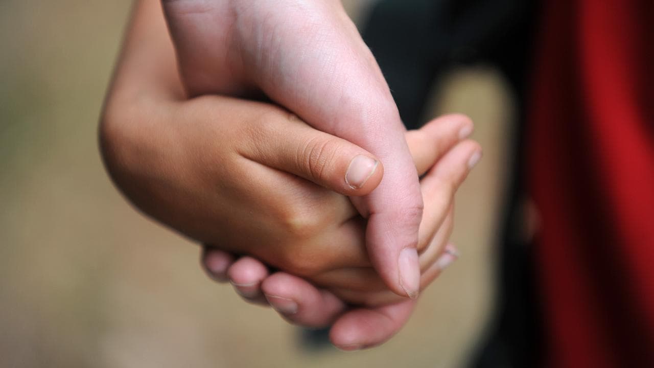 Generic photo of a parent and child holding hands