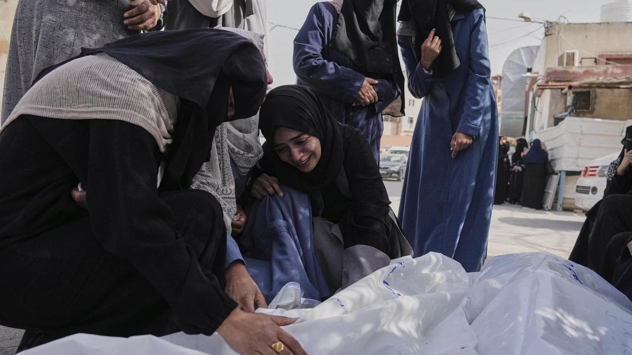 Palestinians next to bodies of relatives in Khan Younis, Gaza Strip