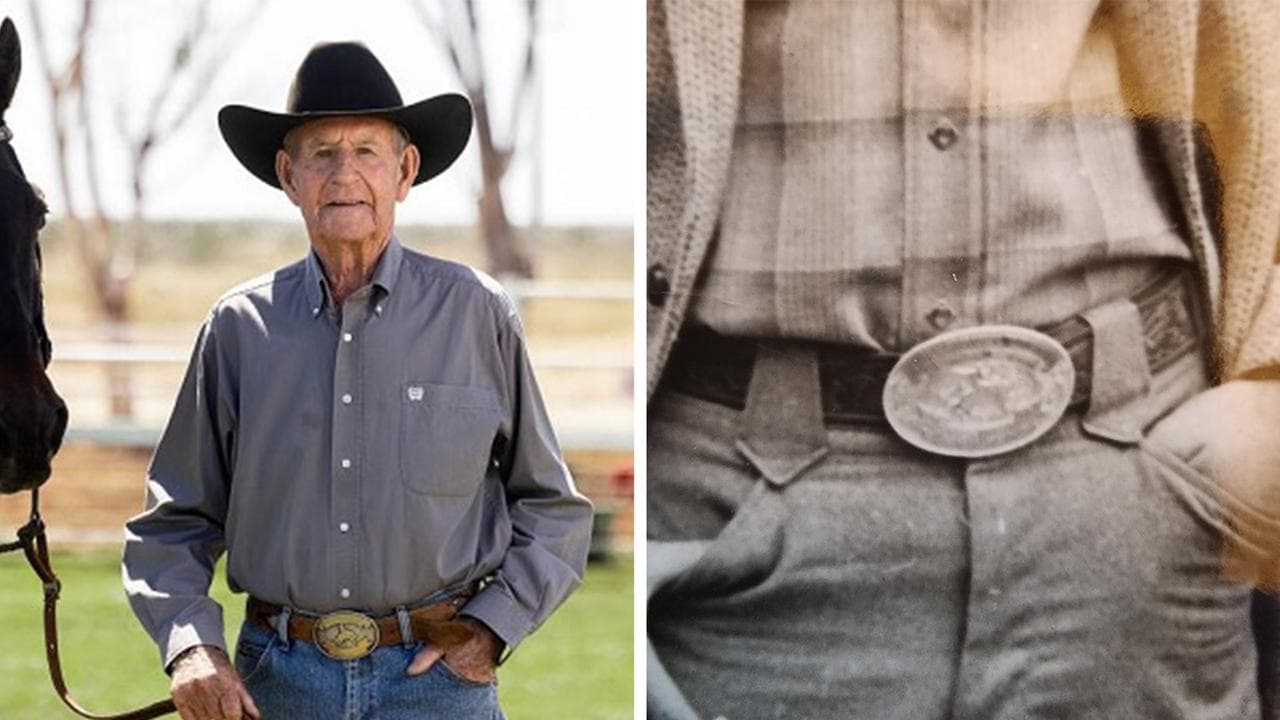 A man in jeans and shirt shows off large oval belt buckle 