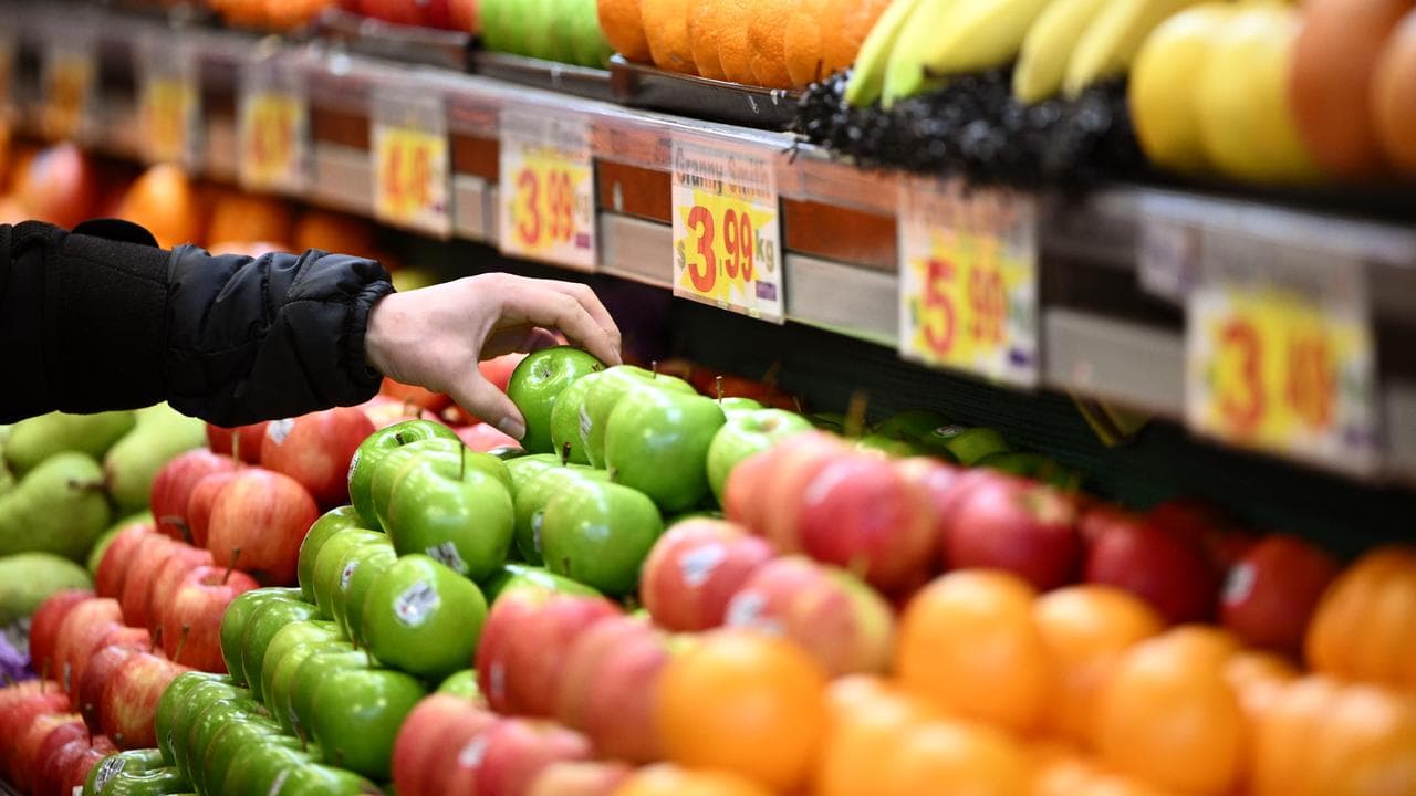 A worker arranges apples for sale at a market (file image)