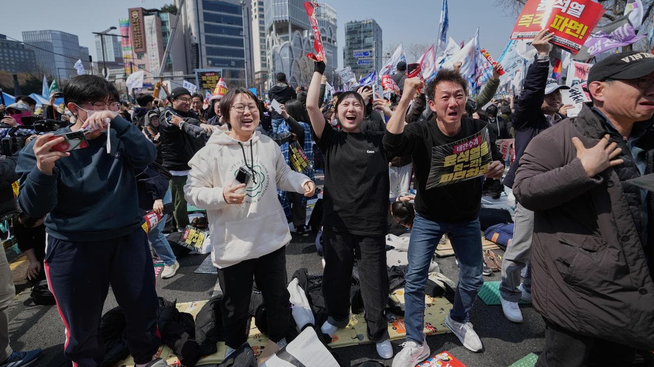 People react after hearing that President Yoon Suk-yeol was removed