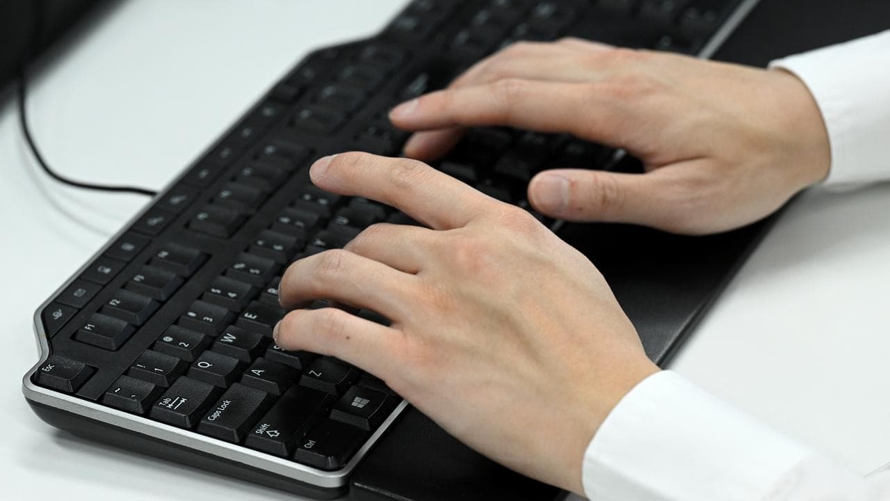 Person types on a keyboard