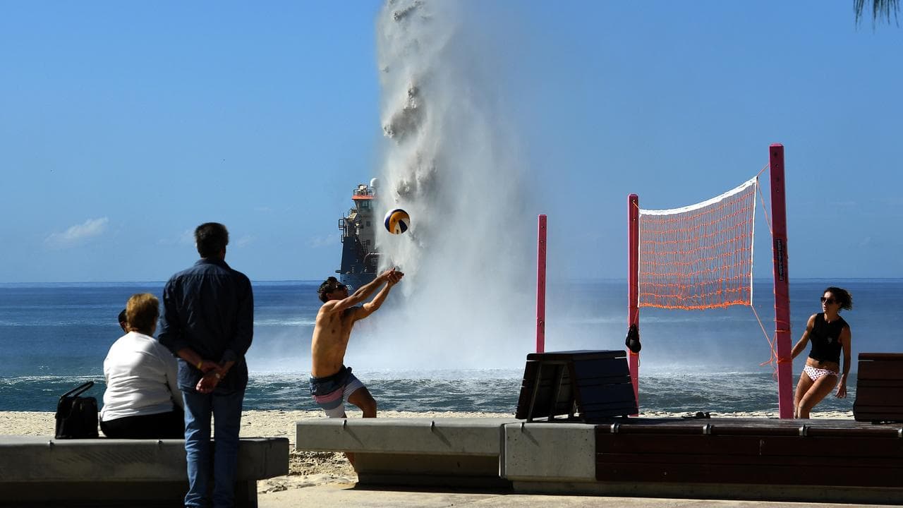 A suction hopper dredger is seen rainbowing sand at Broadbeach