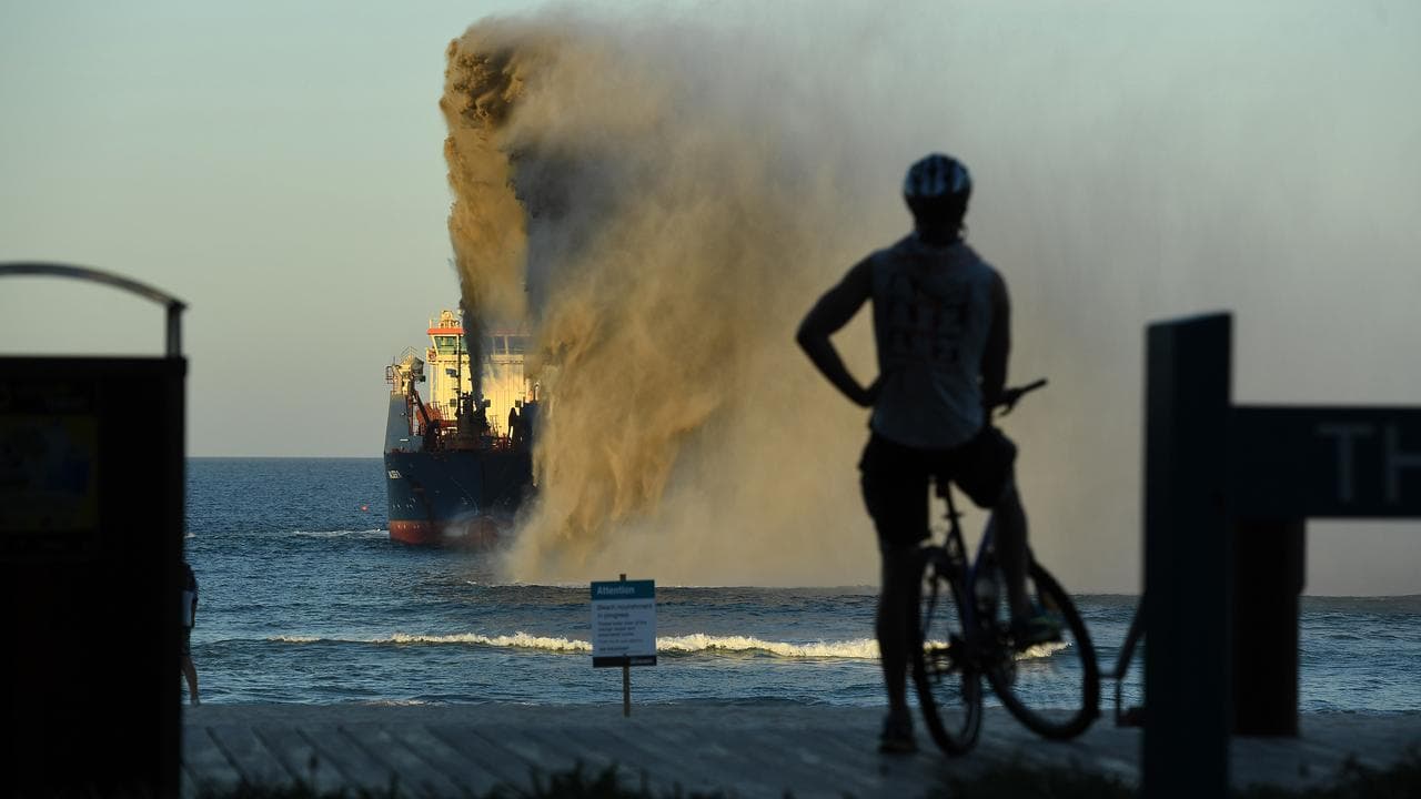 A suction hopper dredger is seen rainbowing sand at Broadbeach