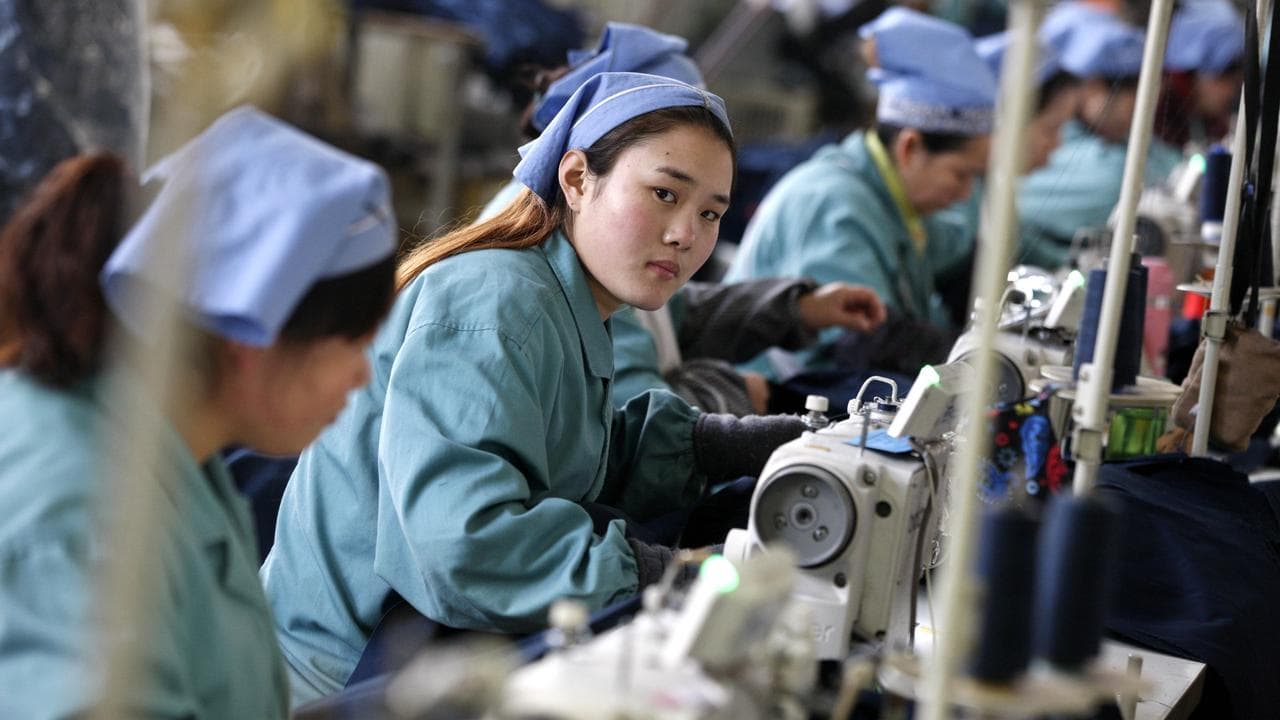 Chinese factory workers sew clothes